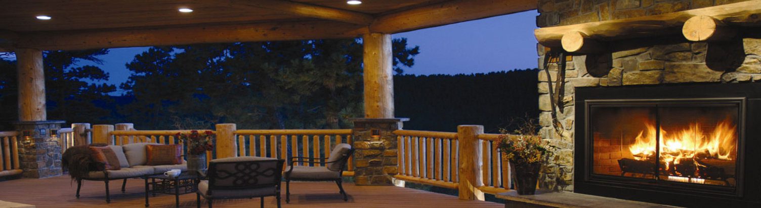 A chair on the porch of a log cabin.