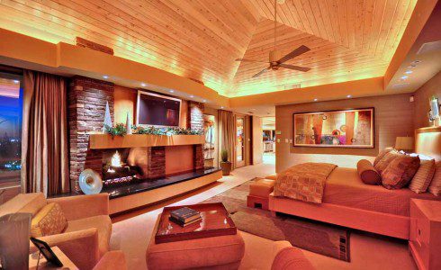 A living room with a fireplace and a television.